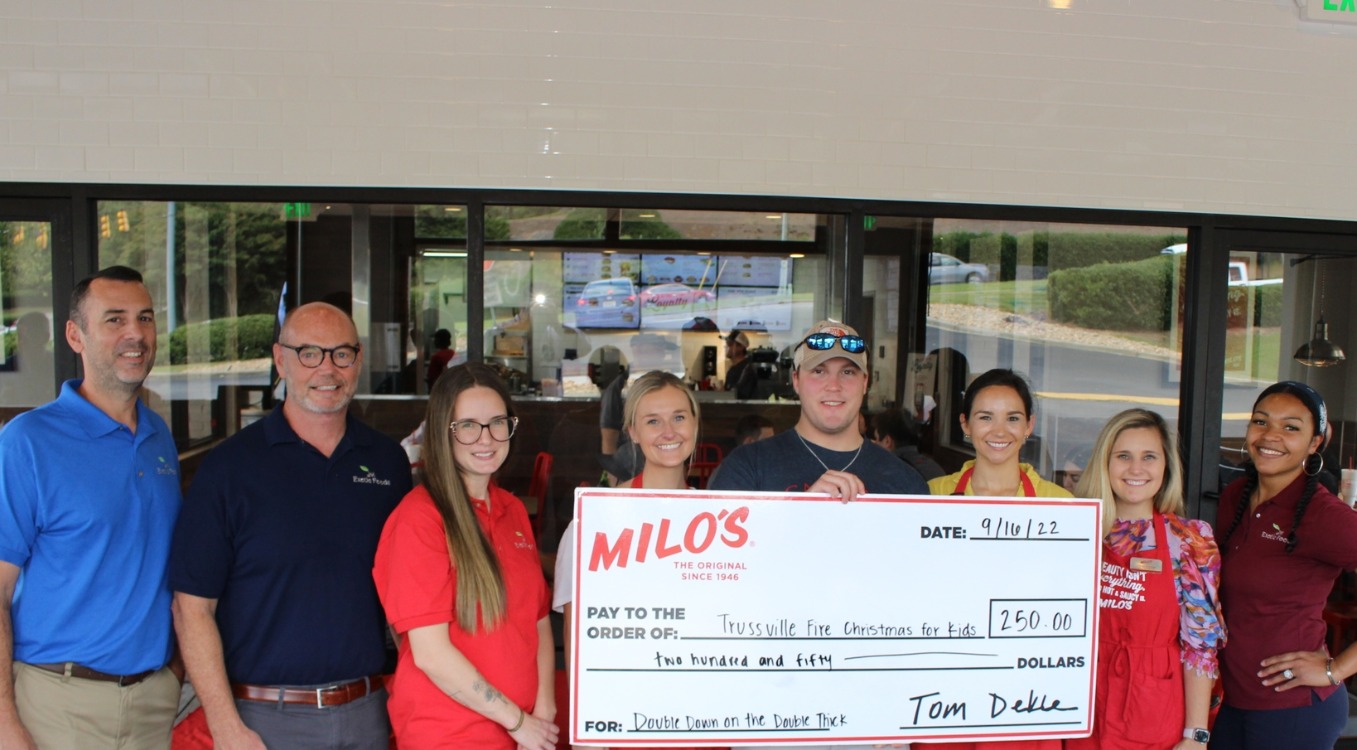 Milos awarding a check to an organization